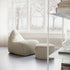 sackit indoor lounge chair and matching pouf in textured light fabric beside a bright window creating a refined Nordic seating area