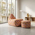 sackit geometric upholstered lounge chair and matching pouf in colorful patterned fabric styled in a bright modern living room