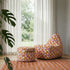 sackit indoor lounge chair and matching pouf with colorful geometric upholstery beside a window in a bright living room
