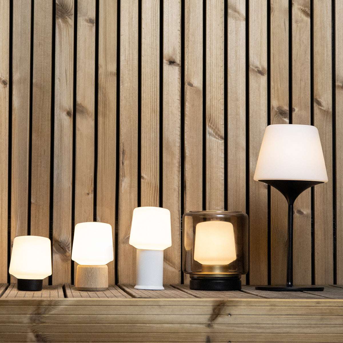Wireless Ambience Lamp Intelligent+ with white polyethylene shade and black base on outdoor surface