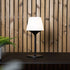 Ambience Lamp Intelligent+ with Aalborg stainless steel base and frostproof glass, shown outdoors on a wooden surface