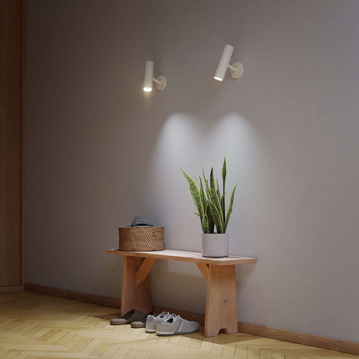White Expo Wall light with aluminum base mounted on a white wall in a minimalistic setting