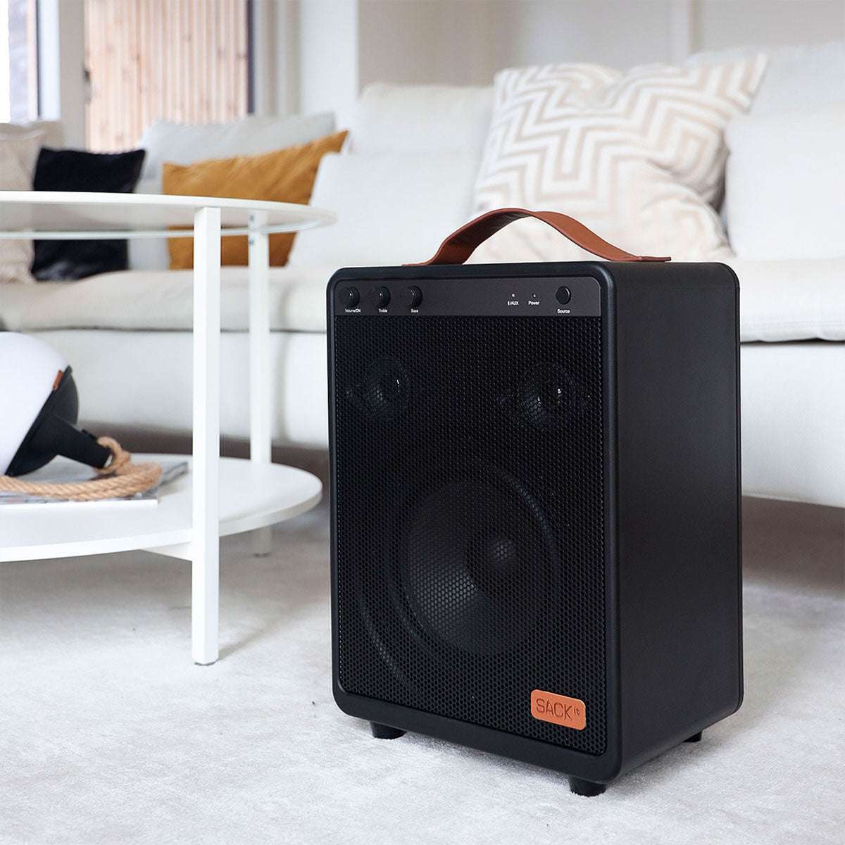 Boom 150 Bluetooth speaker with steel and aluminum design, placed on a wooden surface in a bright room