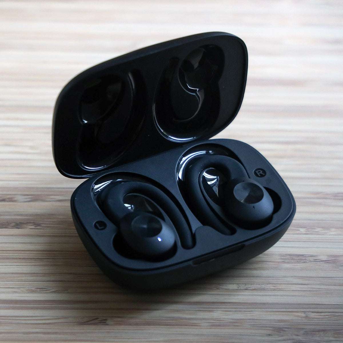Black Active 200 wireless earbuds with charging case and USB cable on white background