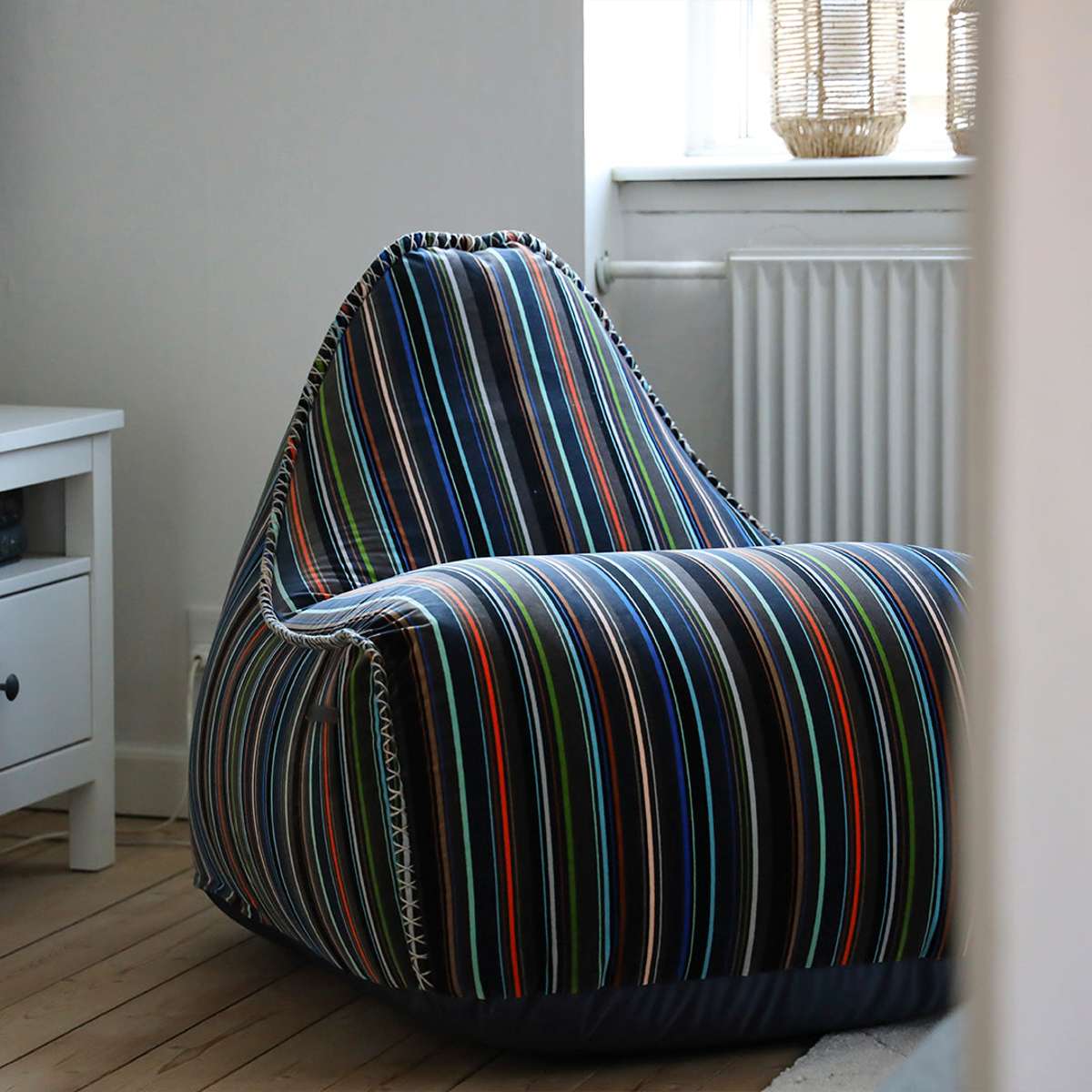 Lounge Chair Paul Smith with multicolored linear cotton upholstery in a modern living room setting