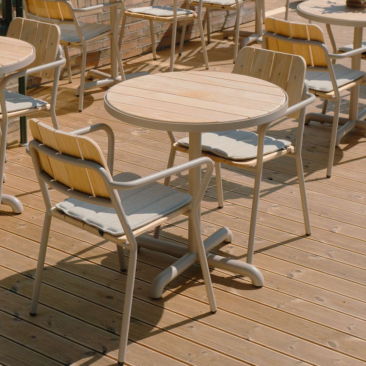Taupe Kirra Café Table with teak wood top and powder-coated aluminum base outdoors on a terrace