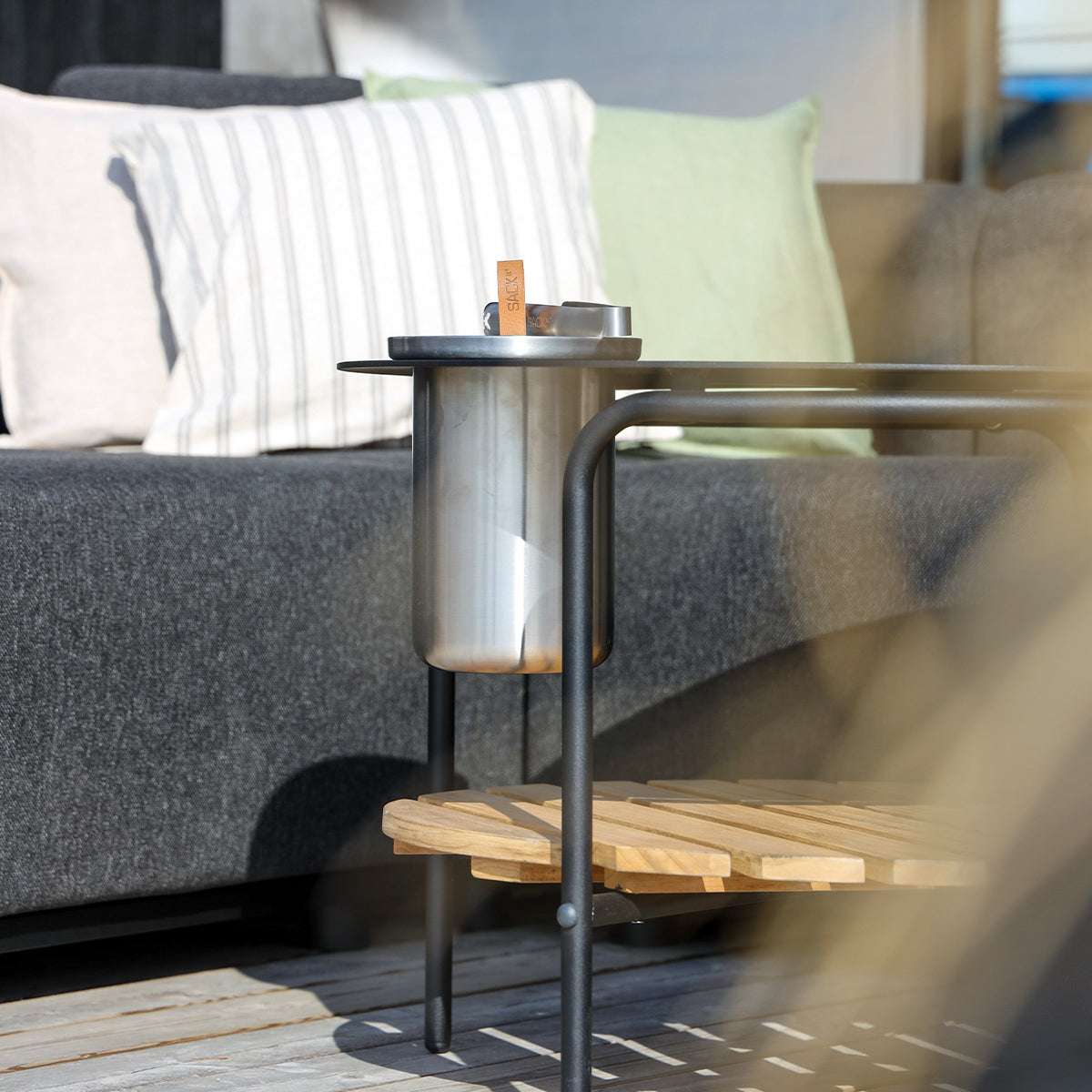 Satin polished stainless steel wine cooler with leather handle and ice tong on a white background