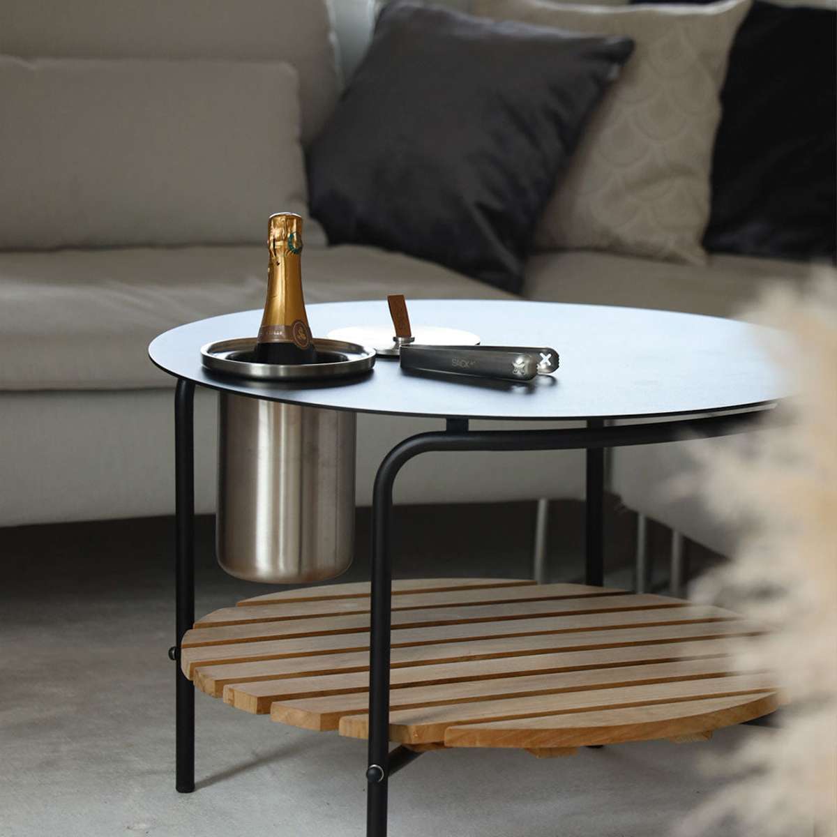 Satin polished stainless steel wine cooler with leather handle and included ice tong on a light surface