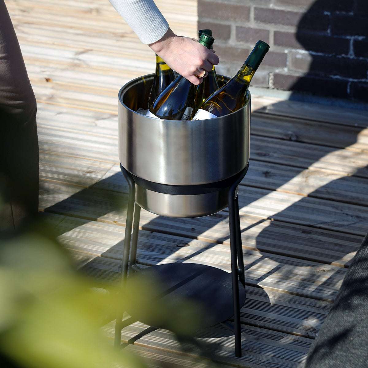 Black powder-coated steel Patio Accessory Stand with stainless steel Wine Bucket on top filled with ice and drinks