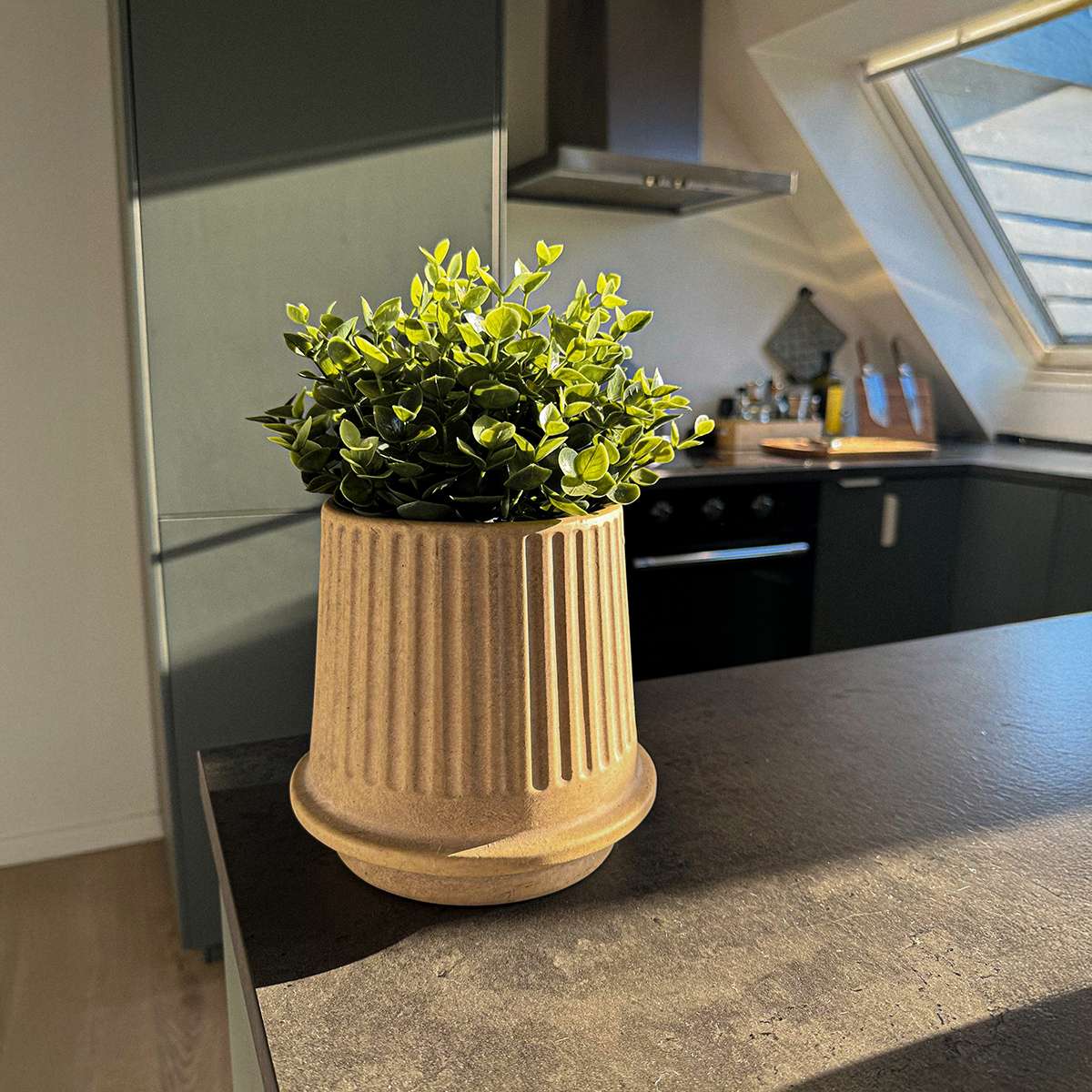 Sand-colored Gaia 16 ceramic outdoor planter with fluted matte surface and drainage hole.