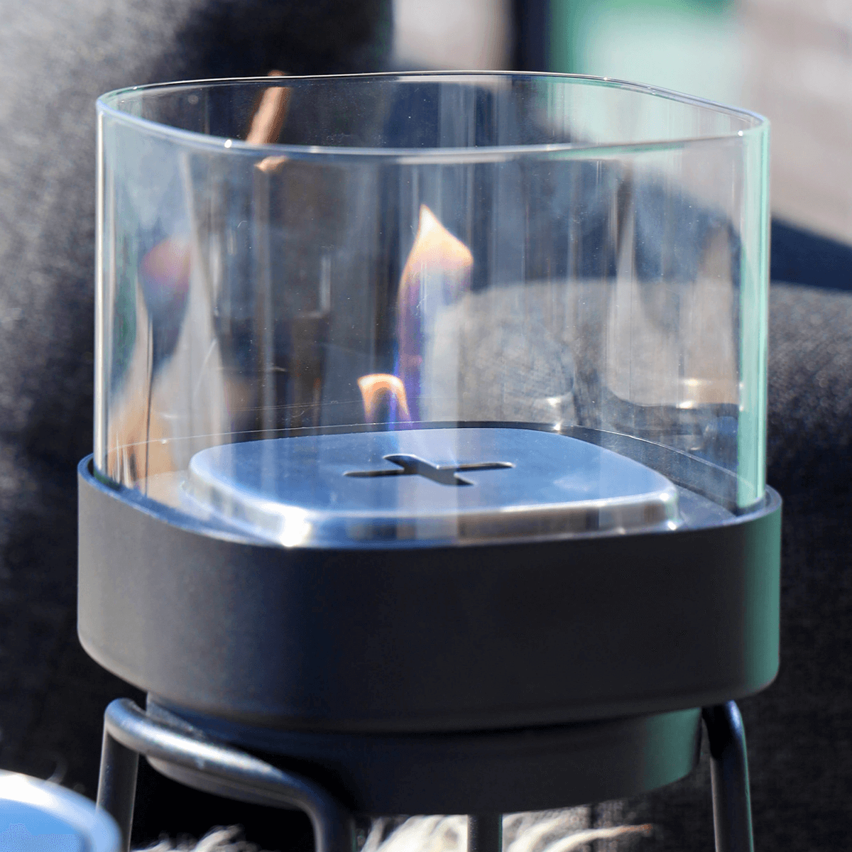 Black stainless steel Bio Lamp with heat-resistant glass and ethanol container on a wooden table outdoors