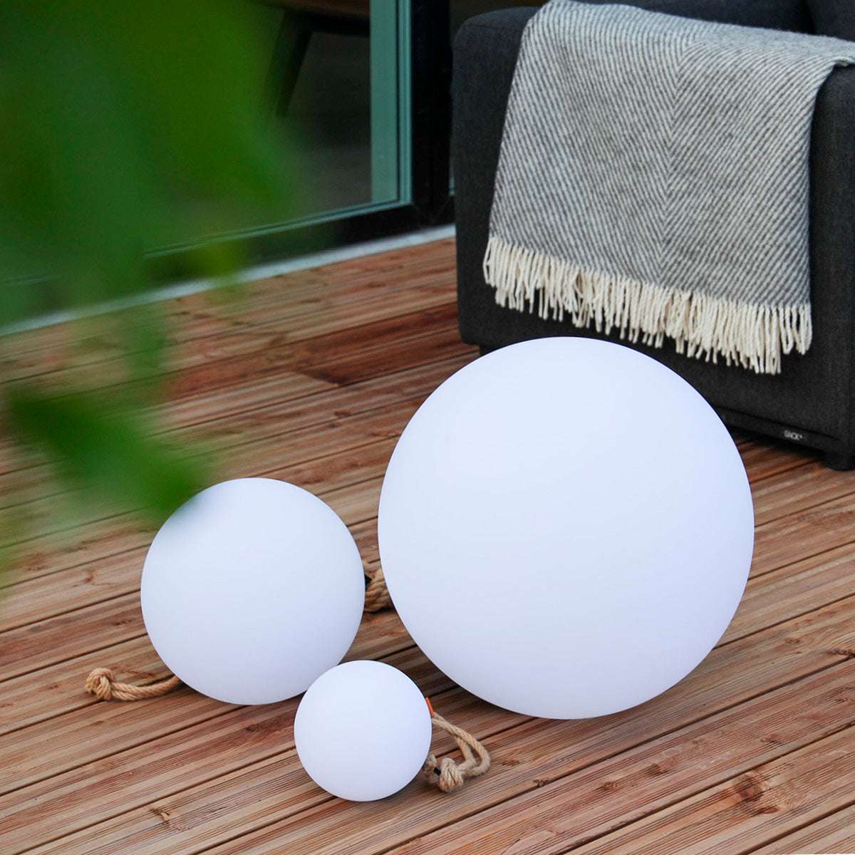Round Light 350 outdoor lamp with white dome and hempen rope handle on a wooden surface