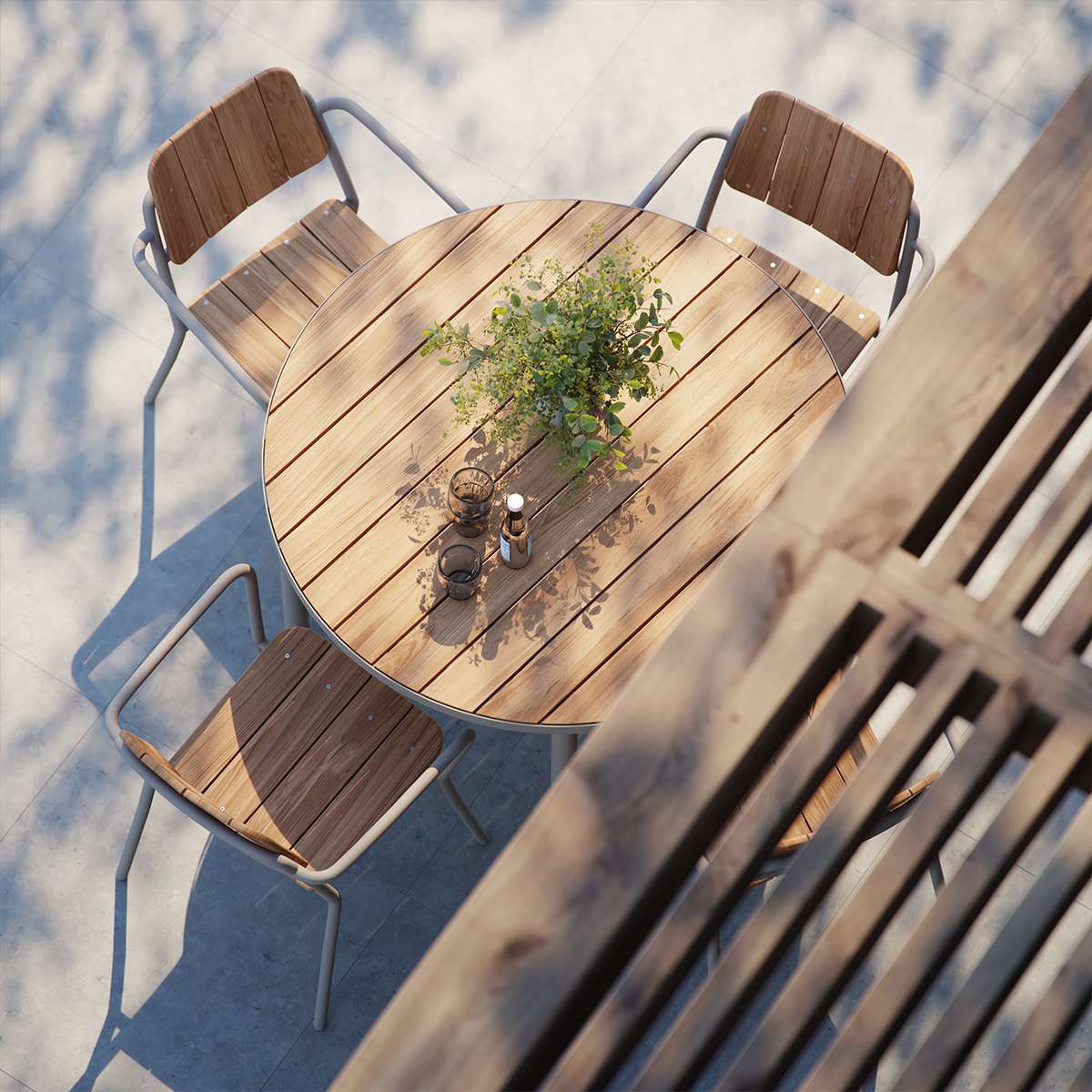 Round taupe Kirra Dining Table with teak wood top and aluminum base outdoors.
