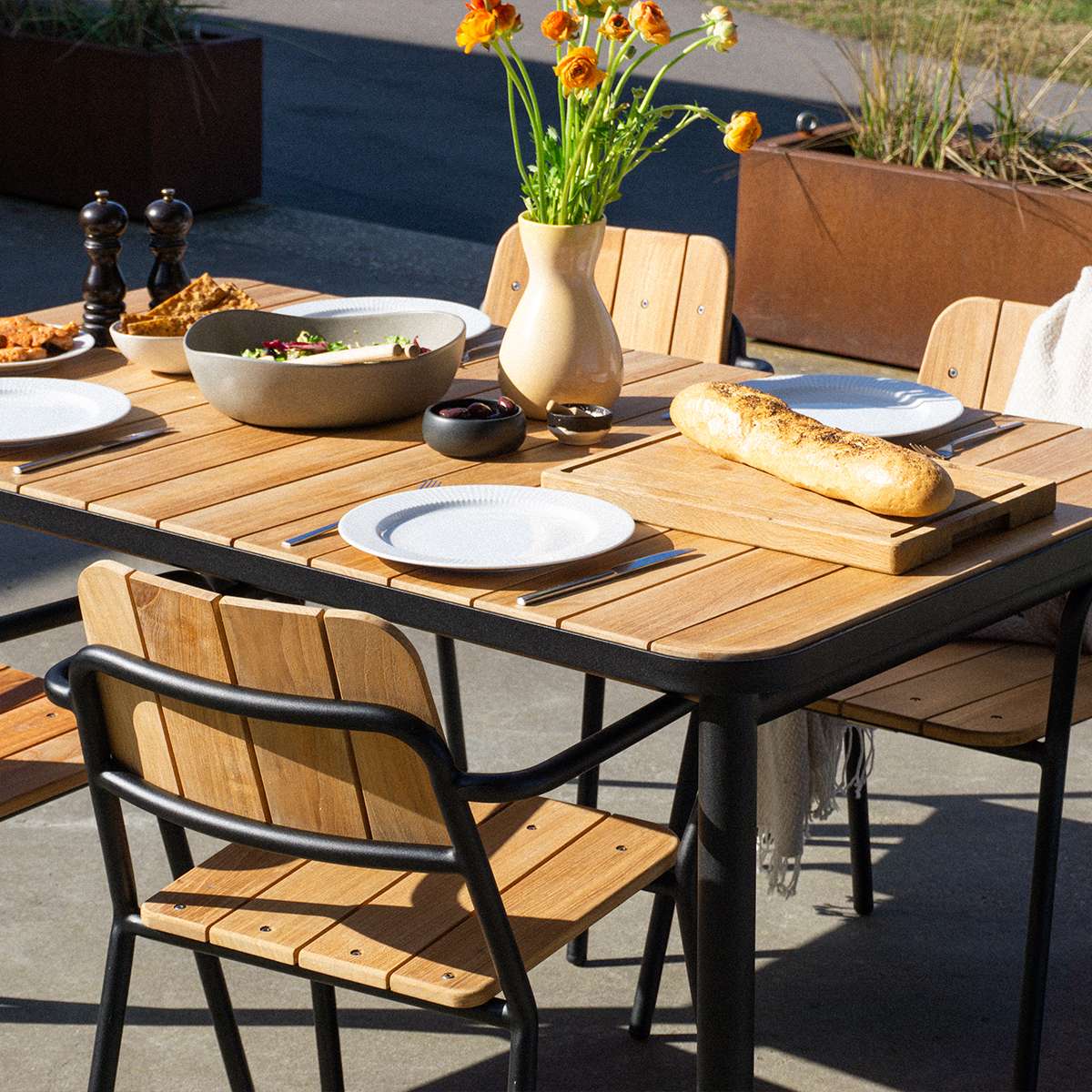 Kirra Dining Table 150x90 with powder-coated aluminum frame and teak wood top in outdoor setting