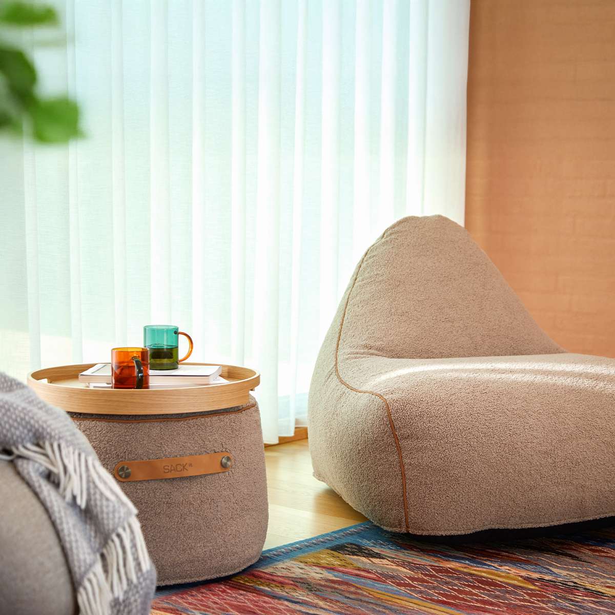 Round Teddy Brown SACKit Pouf Indoor with side handle and non-slip bottom on a light floor