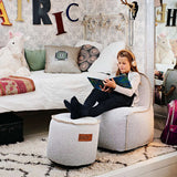 Cobana Junior Lounge Chair and pouf in a neutral indoor setting with soft fabric and rounded shapes.