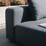 Close view of a dark gray sackit modular outdoor corner sofa with textured upholstery and deep cushions on a sunny patio
