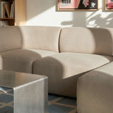Beige Fjord three seat chaise sofa with soft rounded lines in a bright Scandinavian living room beside a metal coffee table from sackit