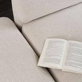 Open book resting on the soft textured cushions of a sackit Fjord corner sofa in a calm Scandinavian interior