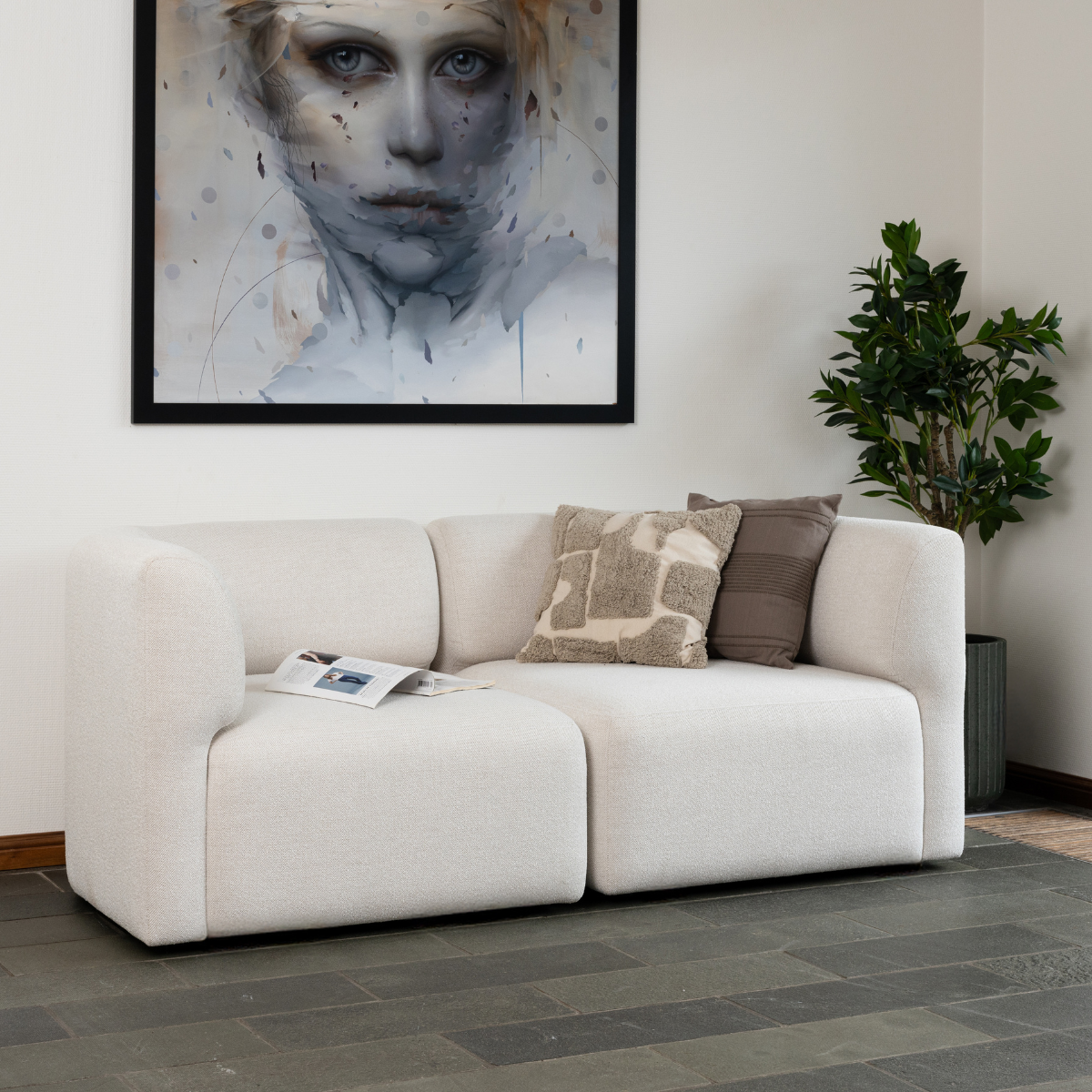 Two-seater Fjord Sofa in light fabric with rounded edges and soft lines in a bright room setting