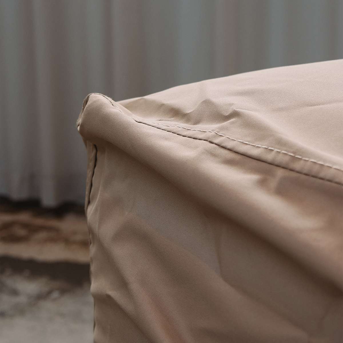 Close view of a sand colored weather resistant cover fitted over a Cobana Lounge Sofa corner module by sackit for outdoor protection