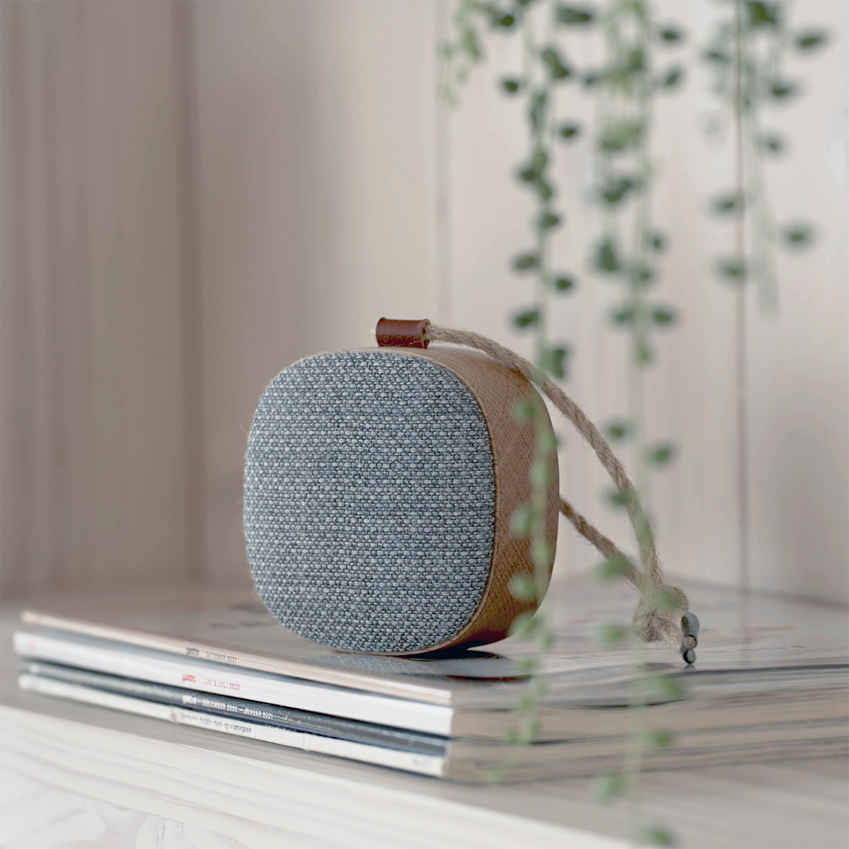 Portable Go Wood speaker with smoked oak frame and Fiord textile by KVADRAT on a white surface