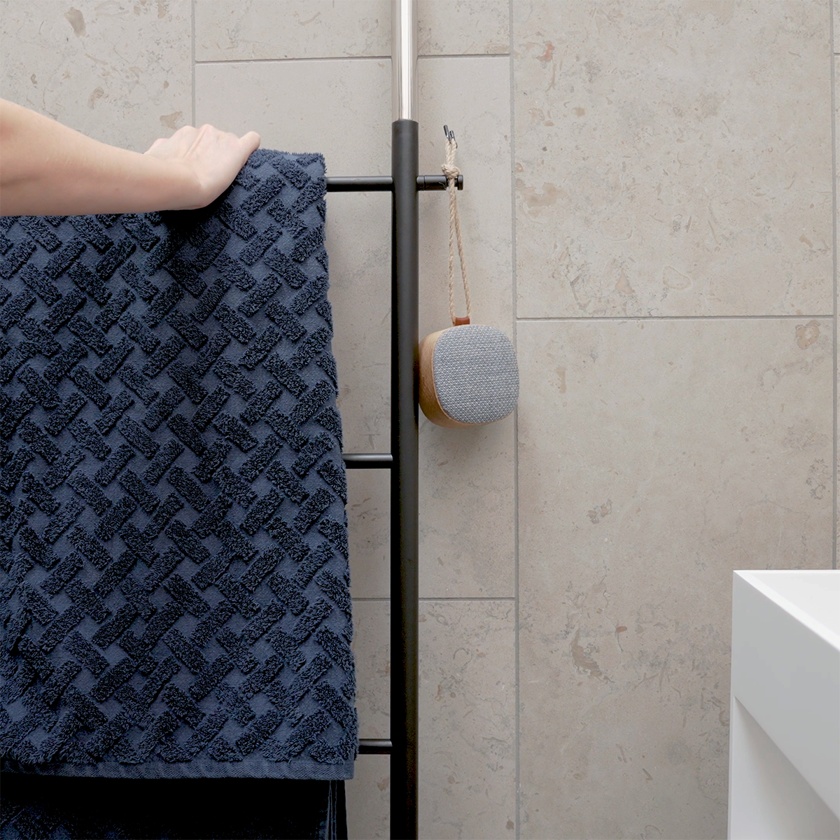 Portable Go Wood speaker with smoked oak frame and Fiord textile from KVADRAT on a white background.