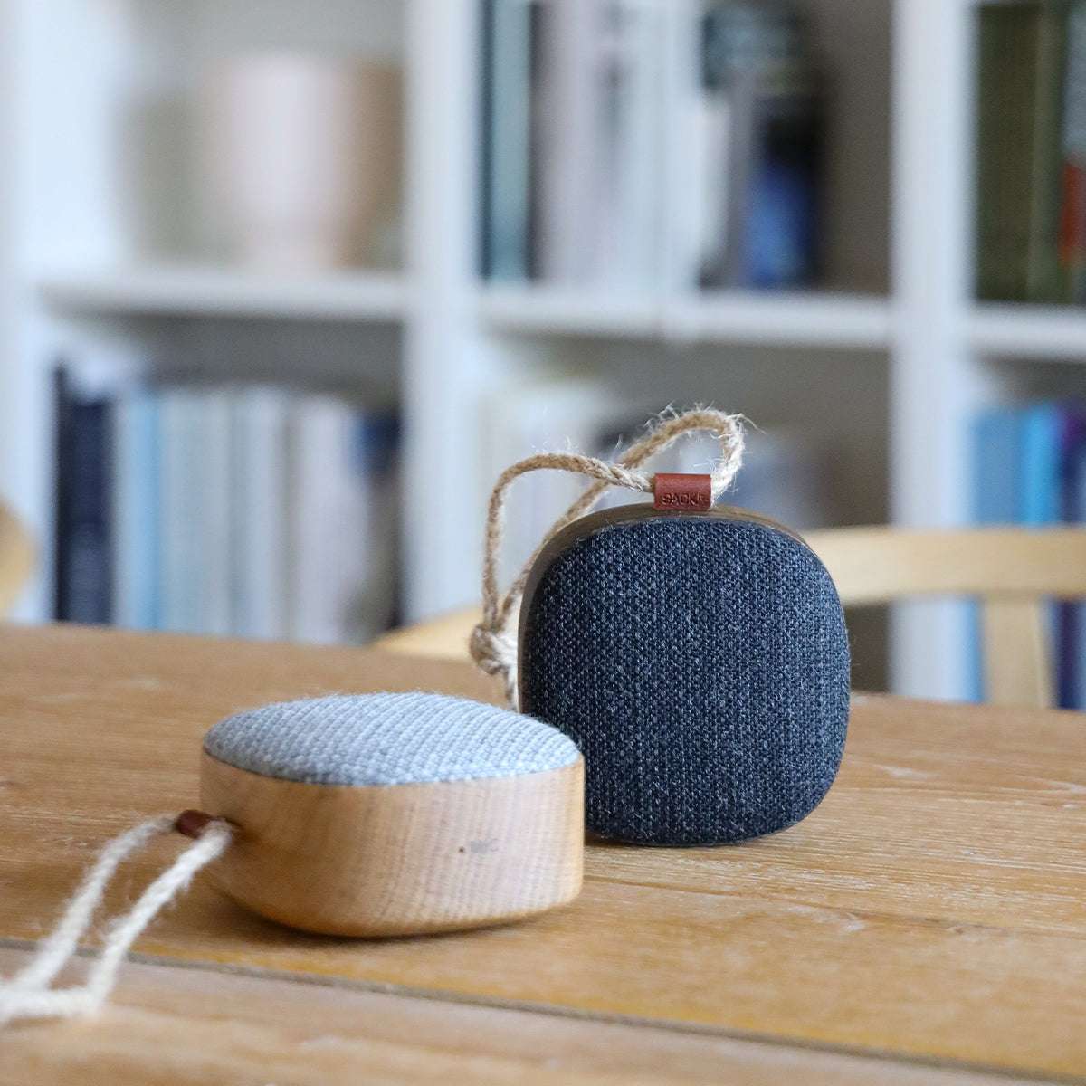 Portable Go Wood speaker with smoked oak wooden frame and Fiord textile from KVADRAT on a white background