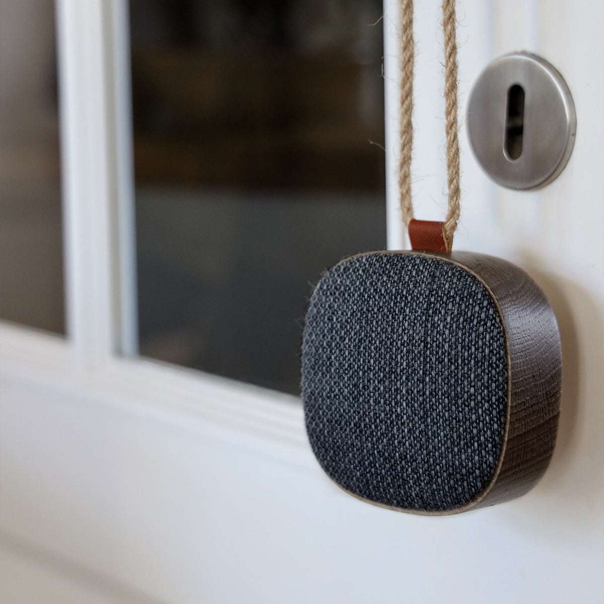 Compact Go Wood portable speaker in smoked oak with Fiord textile, shown on a white surface.