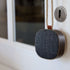 Compact Go Wood portable speaker in smoked oak with Fiord textile, shown on a white surface.