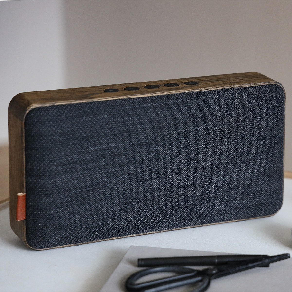 Move Wood Bluetooth speaker in natural oak with Fiord textile and brass details on a light surface
