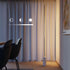 Polished aluminum floor lamp with vertical frosted LED strip and marble base in a minimalist setting