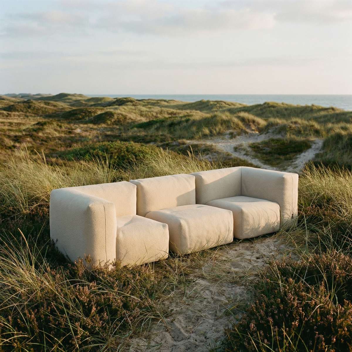 Boucle Beige Soft Sofa Outdoor 3-seater with soft cushions and low backrest placed outside on a patio