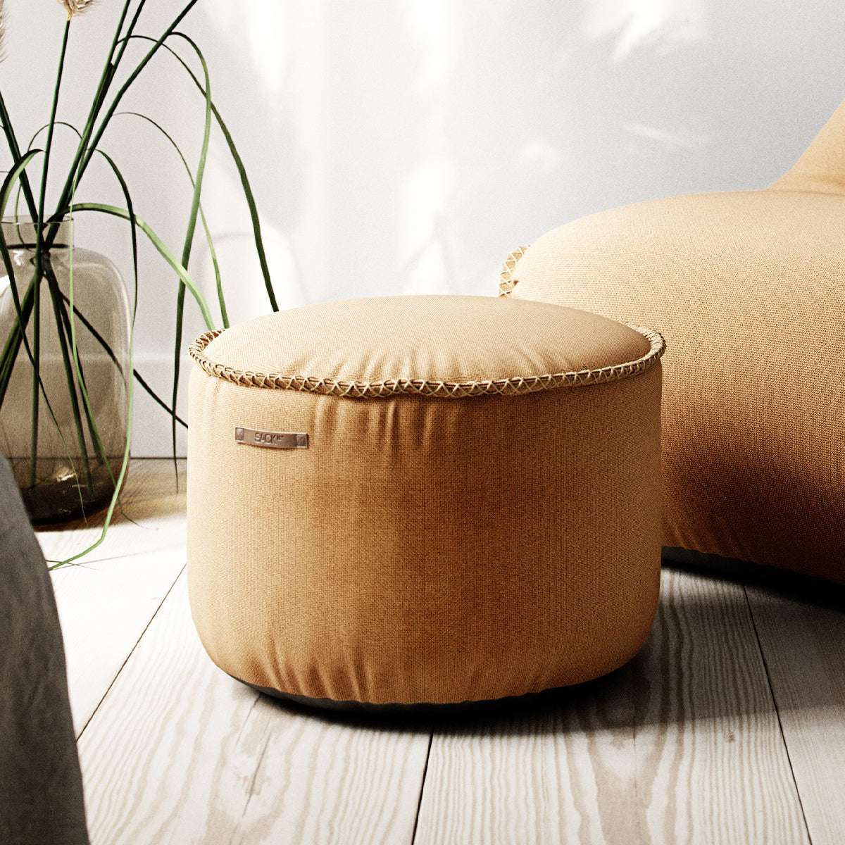 Dark blue Cura Pouf with soft fabric and hand-sewn stitches, round shape on a light background