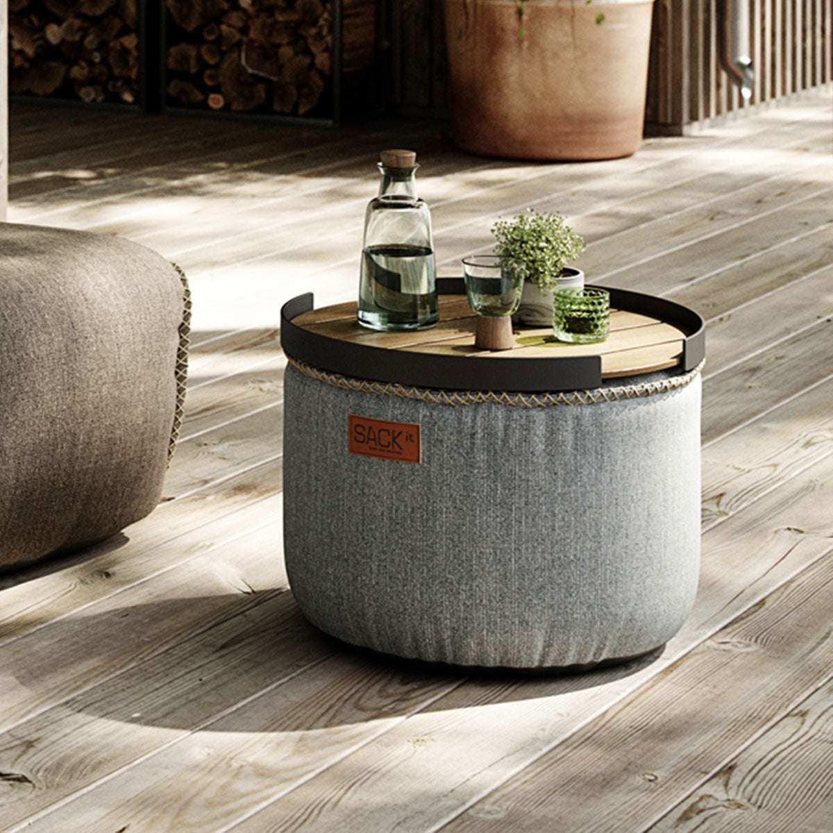 Round Cobana Grey pouf with textured fabric and hand-sewn stitches on a white background.