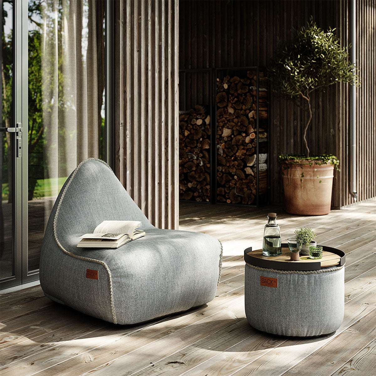 Round Cobana Grey pouf with textured fabric and hand-sewn stitches, suitable for indoor and outdoor use.