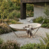 Cream outdoor hammock with a soft patterned blanket in a landscaped garden beside a modern Nordic style home for comfortable summer lounging