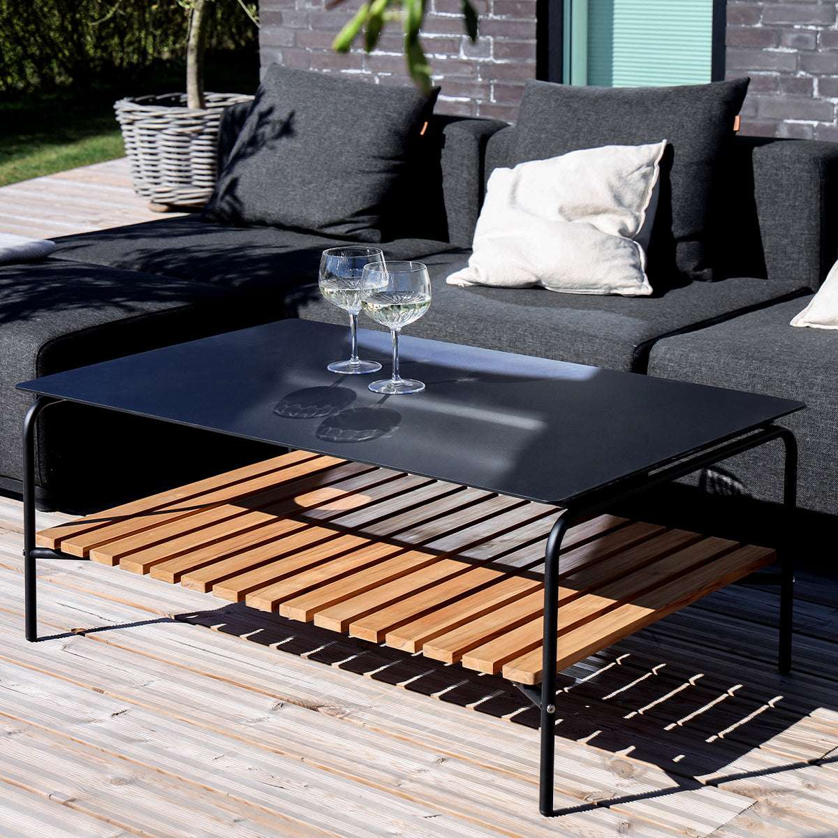 Outdoor patio sofa table with black powder-coated aluminum frame and teak wood shelf underneath