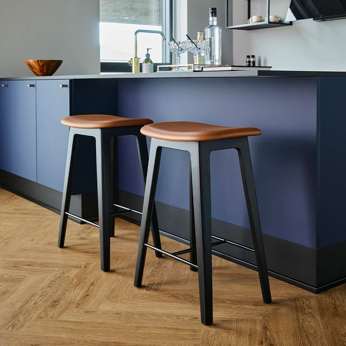 Nordic bar stool with black stained oak frame and Terra Black leather seat with powder-coated steel footrest