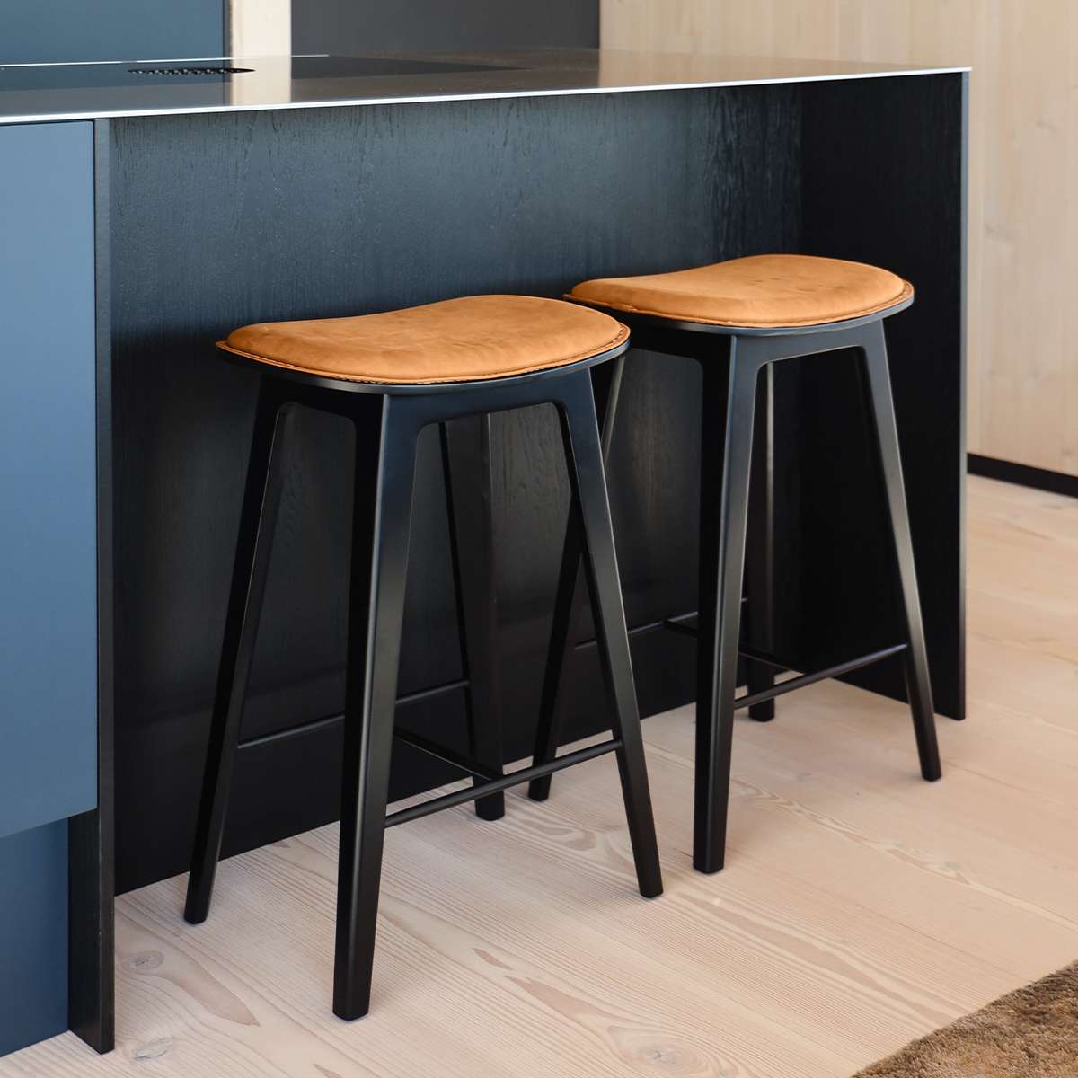 Nordic bar stool in black stained oak with Terra Black leather upholstery and subtle stitching detail.
