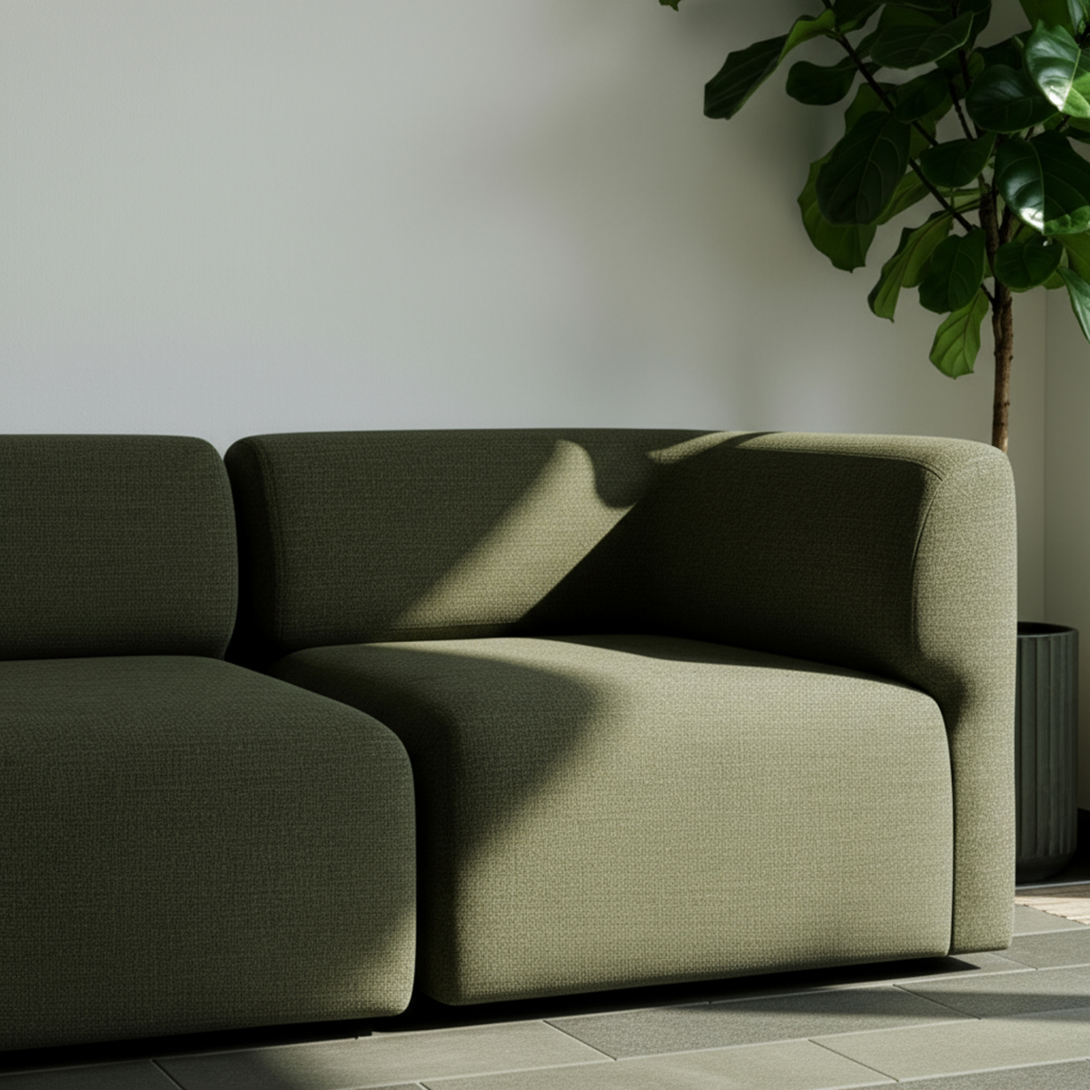 Olive green three seat Fjord sofa in a calm Scandinavian interior with sunlight and a leafy plant from sackit indoor furniture