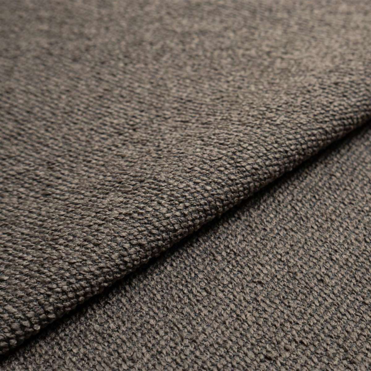 Close up of taupe textured upholstery fabric from the sackit Fjord Sofa in a warm neutral tone with a soft woven surface and refined Scandinavian feel