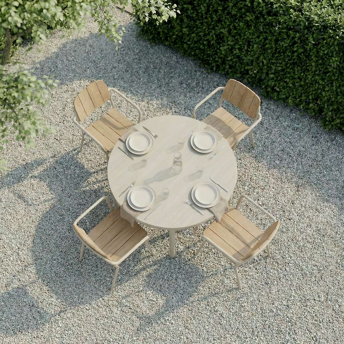 Round taupe Kirra Dining Table with teak wood top and powder-coated aluminum frame outdoors.