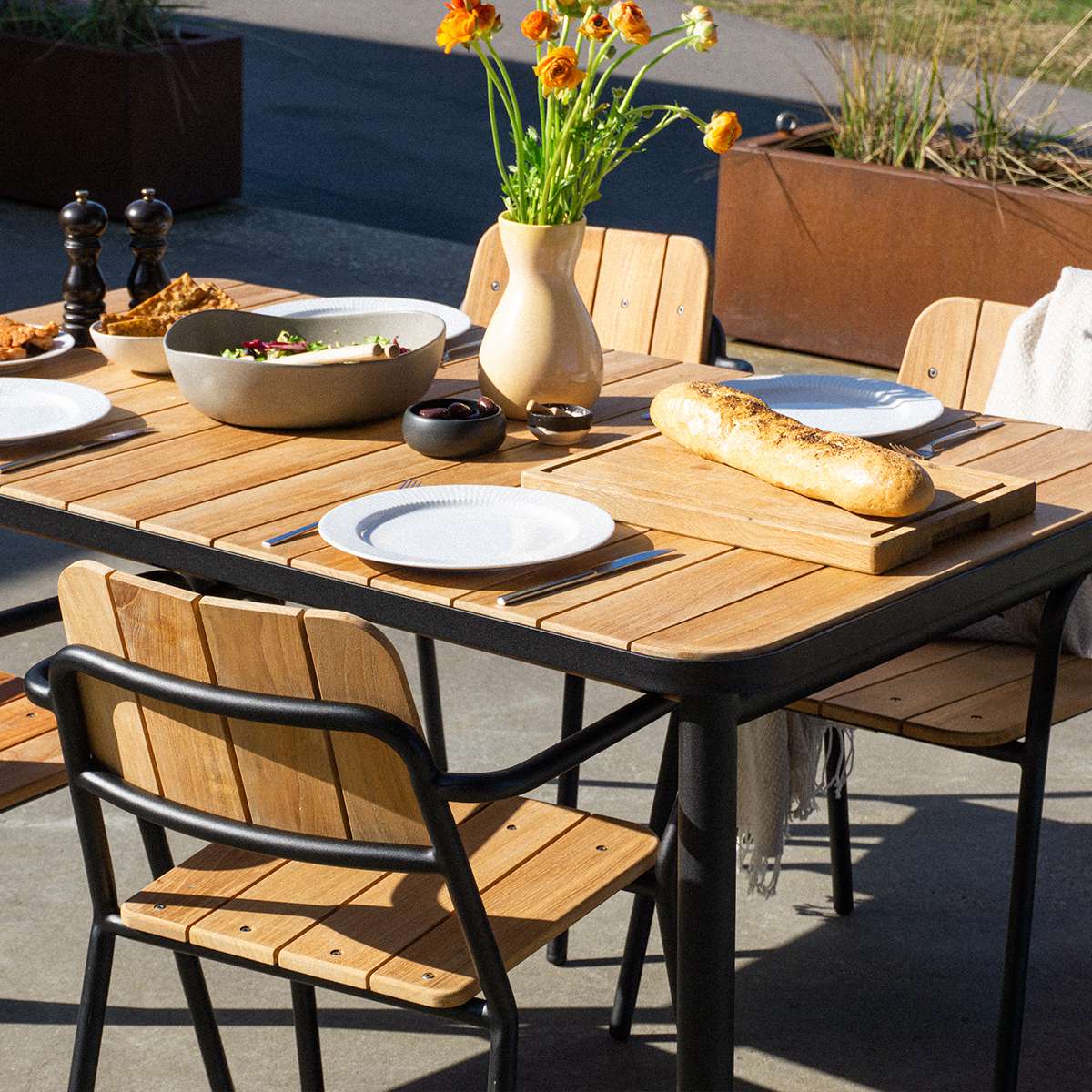 Kirra Patio Chair with powder-coated aluminum frame and teak wood seat in outdoor setting