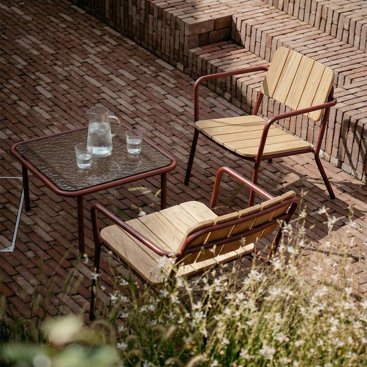 Square Mollis Coffee Table in chestnut with powder-coated aluminum frame and smoked tempered glass top outdoors