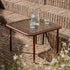 Square Mollis Coffee Table with chestnut powder-coated aluminum frame and smoked tempered glass top outdoors